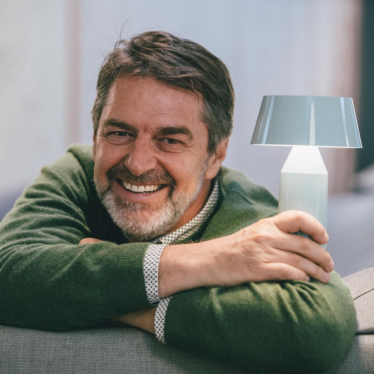 Designer Christophe Mathieu mit seiner Marset Bicoca LED Akkuleuchte, hellblau