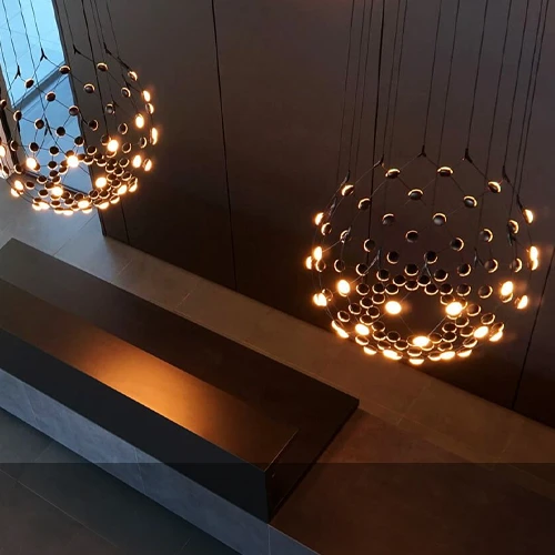 Several Luceplan pendant lights with warm illumination above a stylish interior counter